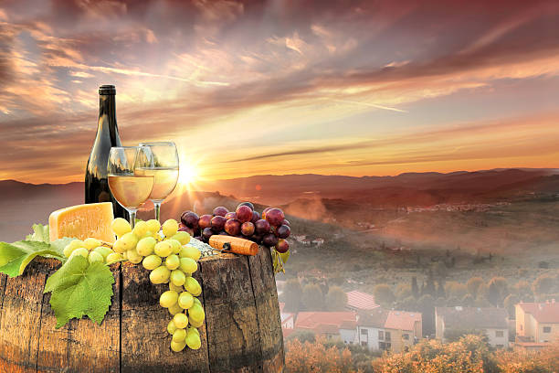 istock White wine with barrel on famous vineyard in Chianti, Italy 597949170