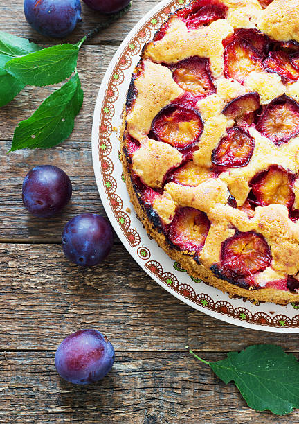 istock rustic plum cake on dark wooden background 597949444