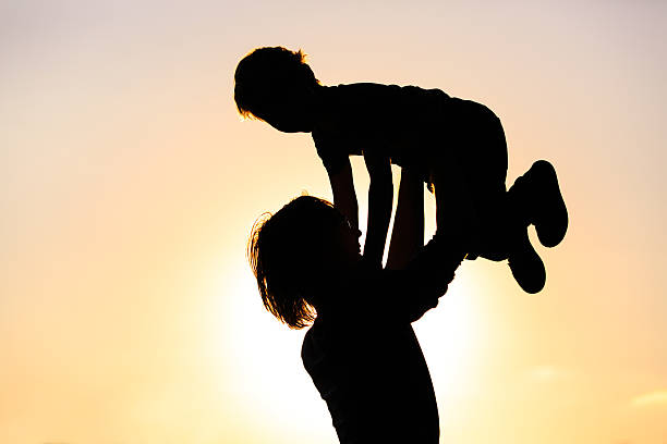 istock father and little son silhouettes play at sunset 597952622