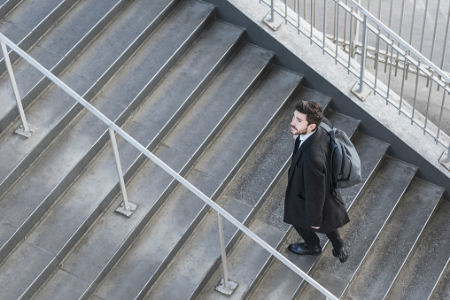 Overhead portrait on businessman walking up stairs on his daily commute to work.