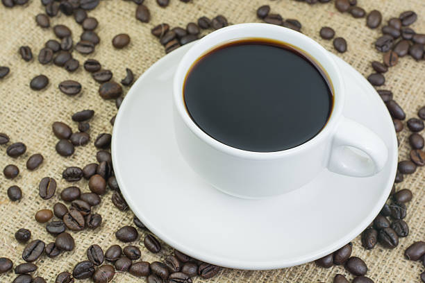 istock White cup with coffee drink on jute bag background 597958554