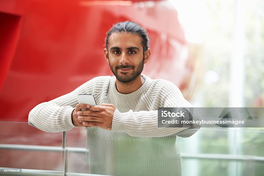 Asiatische männliche Universität Student hält Smartphone, Porträt - Lizenzfrei Indischer Abstammung Stock-Foto