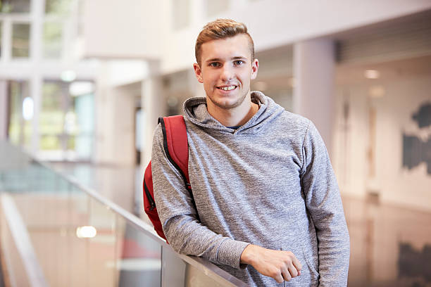 young adult male student in the lobby of a university - europese etniciteit fotos stockfoto's en -beelden