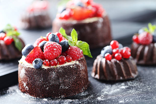 istock Sweet chocolate cakes with berries on black wooden table 597958790