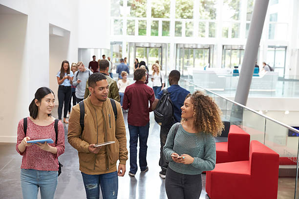 studenci trzymający tablety i rozmowy telefoniczne w lobby uniwersyteckim - adult student university student asian ethnicity zdjęcia i obrazy z banku zdjęć