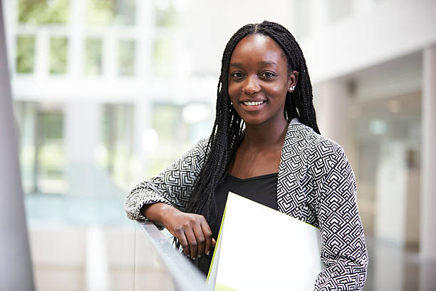 une jeune étudiante noire souriante dans le foyer universitaire - atrium élément architectural photos et images de collection