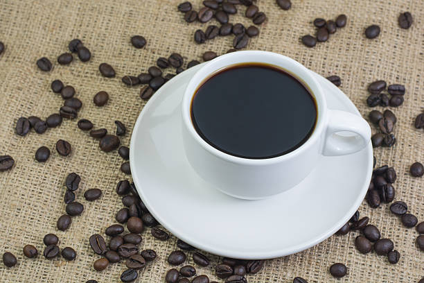 istock White cup with coffee drink on jute bag background 597958972