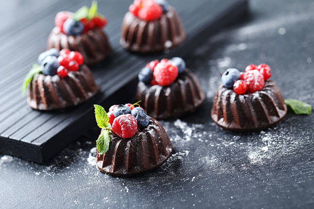 istock Sweet chocolate cakes with berries on black wooden table 597959036
