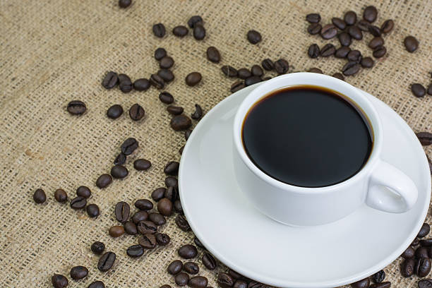 istock White cup with coffee drink on jute bag background 597959040