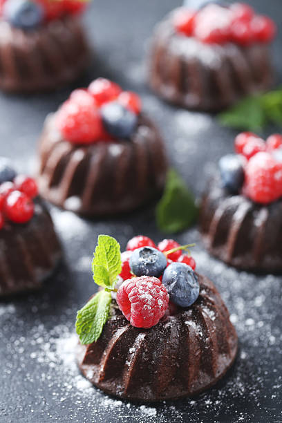 istock Sweet chocolate cakes with berries on black wooden table 597959152