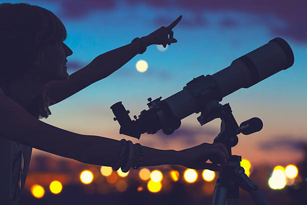 garota olhando para as estrelas com telescópio ao lado dela. - telescópio astronômico - fotografias e filmes do acervo