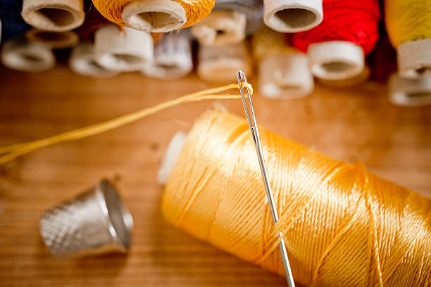 needle with thread,shallow depth of field - thimble sewing item close up studio shot imagens e fotografias de stock