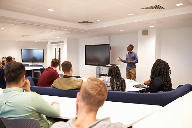 istock University students study in a classroom with male lecturer 597963358