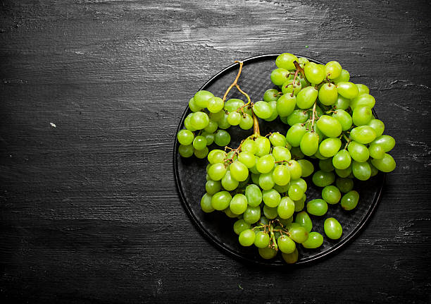 istock Branch of white grapes on a plate. 597963380