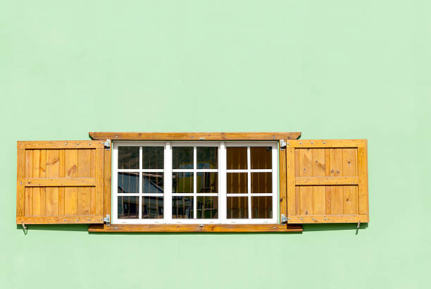 istock Colorful Caribbean Window and Shutters in a Green Wall 597963996