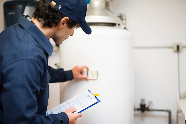 Idraulico riparazione un riscaldatore di acqua calda - foto stock