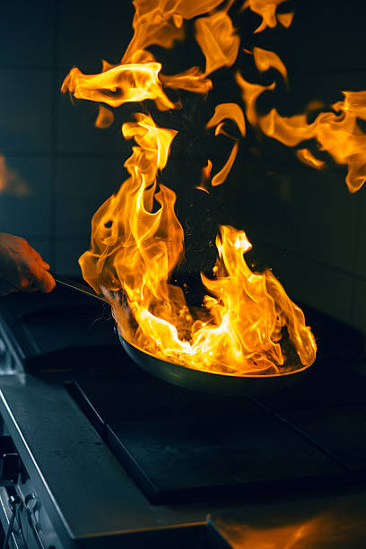 istock Chef holding flaming pan 597968378