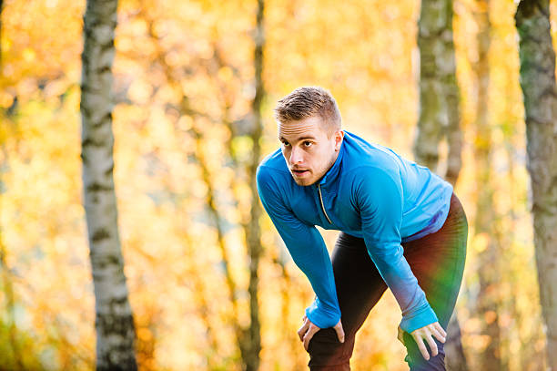 istock Young handsome hipster runner outside in sunny autumn nature 597968438