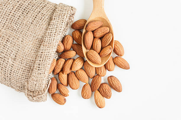 istock almonds on wooden spoon isolated over white background 597968566