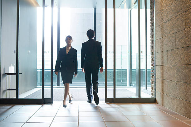 istock Japanese employees walking through doorway 597970316