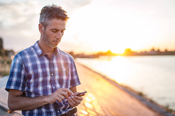 istock Businessman on sidewalk looking at smartphone 597972146