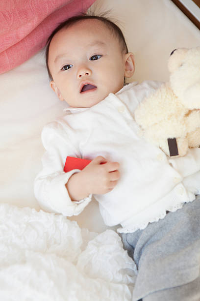 istock Young Japanese boy playing on a bed 597973586