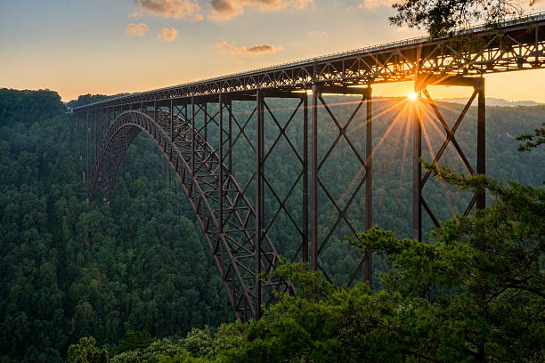 Sunset at the New River Gorge Bridge in West Virginia Setting sun behind the girders of the high arched New River Gorge bridge in West Virginia appalachia photos stock pictures, royalty-free photos & images