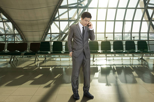 businessman calling a telephone in terminal airport - suit male beauty men businessman imagens e fotografias de stock