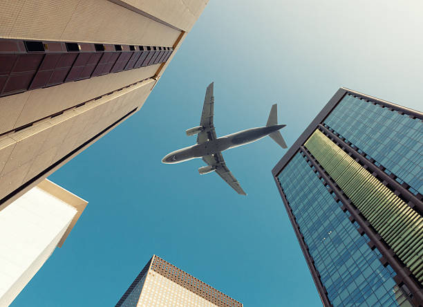 istock Plane flying over a business skyscrapers filled with offices 598052650