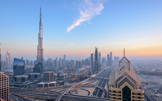 Sunset over Dubai showing Sheik Zayed Road and sunset over city with Burj Khalifa and Downtown business district. UAE.