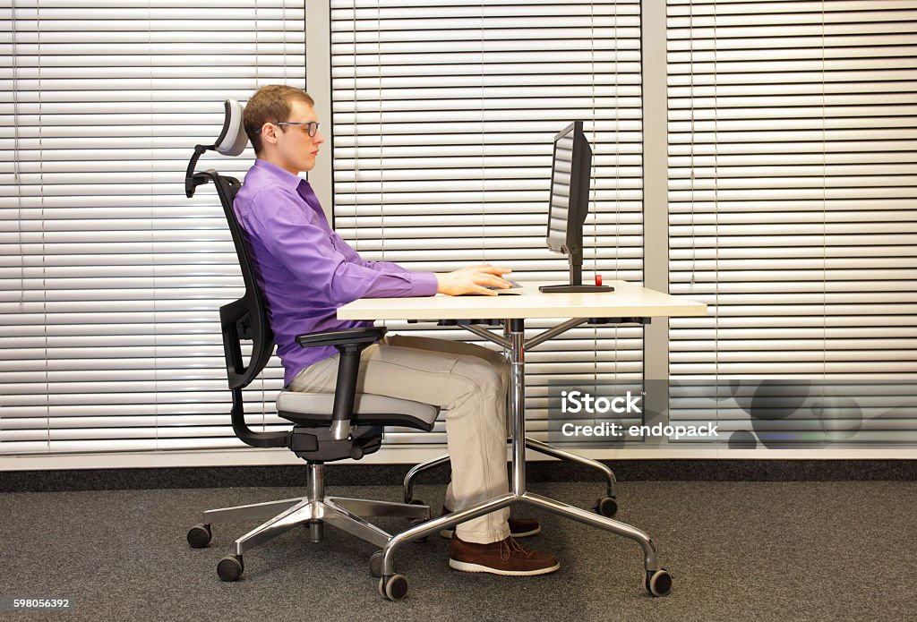 correct sitting position at workstation with computer correct sitting position at workstation. man on chair working with computer Ergonomics Stock Photo