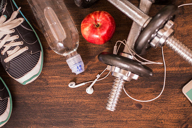 Fitness, exercise themed scene with barbells, sneakers, earbuds.