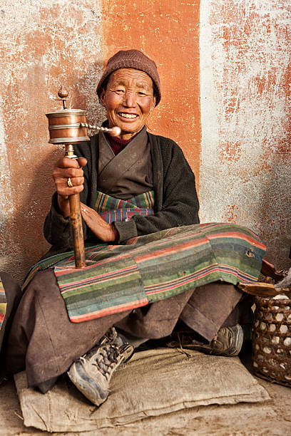 istock Tibetan woman holding praying wheel, Upper Mustang 598058150