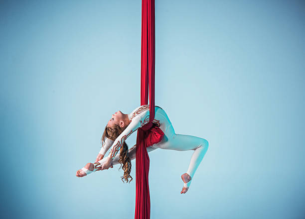 elegantes gimnasta realiza aérea de ejercicio - acróbata circo fotografías e imágenes de stock