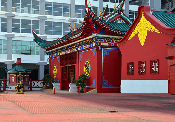Bandar Seri Begawan, Brunei Darussalam: Tiang Yun Dian Chinese Temple - the 'Temple of Flying Clouds' - red façade on Jalan Sungai Kianggeh with moon windows and Ceremonial Burner - in the background the Ministry of Finance tower (PGGMB Building) - photo by M.Torres