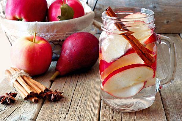 água desintoxicação de outono com maçã, canela e pera - apple red fruit water - fotografias e filmes do acervo