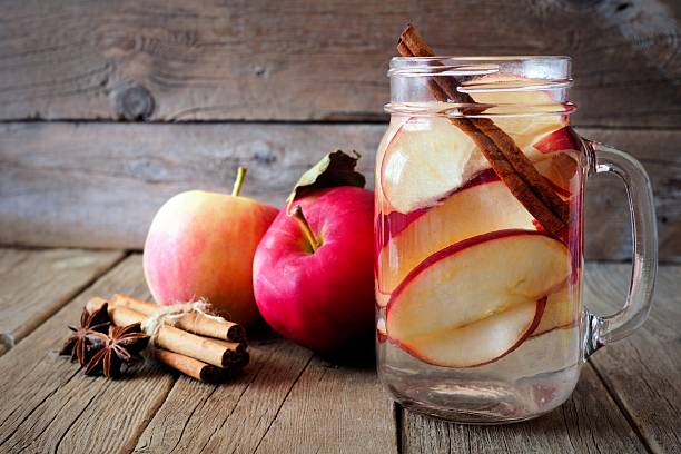 água desintoxicação de outono em um pote de pedreiro em madeira rústica - apple red fruit water - fotografias e filmes do acervo