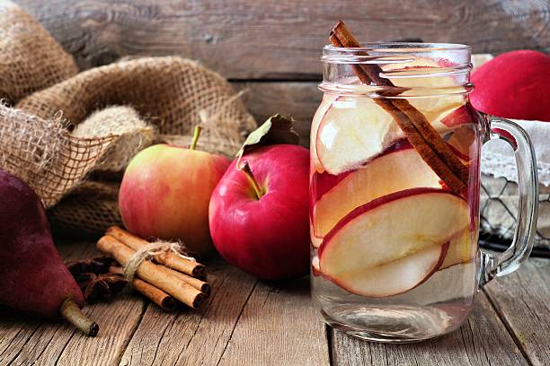 água desintoxicação de outono com maçã, canela e pera vermelha - apple red fruit water - fotografias e filmes do acervo