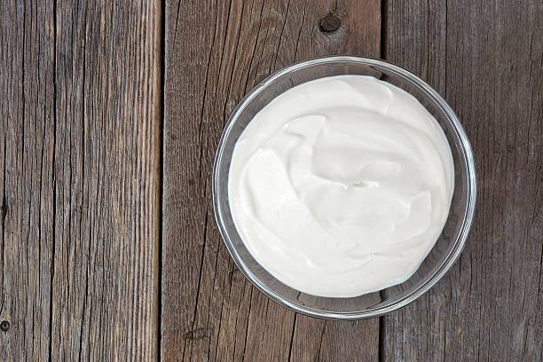 istock Greek yogurt in clear bowl, above view on rustic wood 598061888