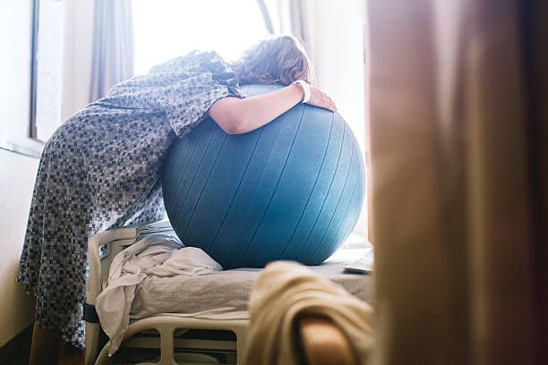 mujer embarazada en la cama de hospital  - pelota de ejercicio fotografías e imágenes de stock