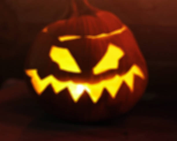 istock defocused Halloween jack o lantern with glowing candles background 598063290
