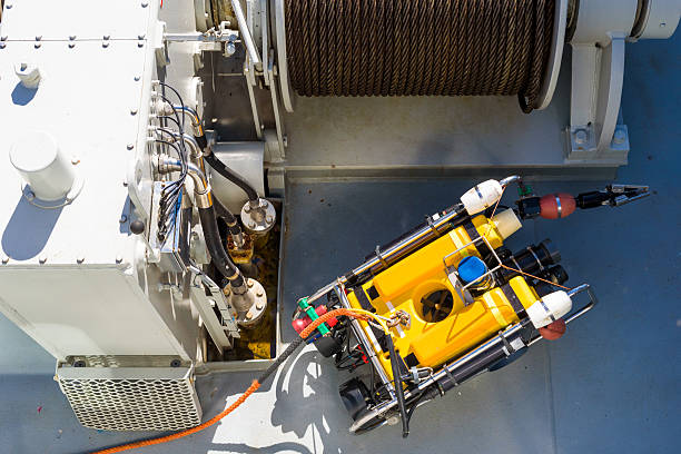 Mini submarine Small yellow mini submarine with gripping claw and rope attached seen from above. Tugging winch in background with winch machinery to the left. winch cable stock pictures, royalty-free photos & images