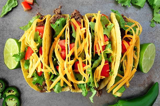 Traditional hard shelled tacos, overhead view on rustic tray