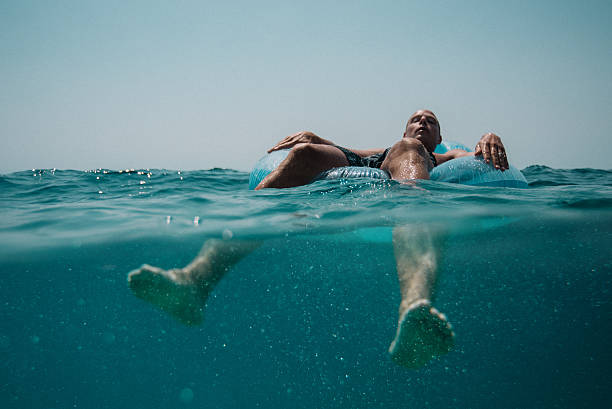 man floating in the mediterranean sea in croatia - inflatable raft imagens e fotografias de stock