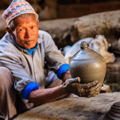 Nepalese potter working in his workshop on pottery square in Bhaktapur. Bhaktapur is an ancient town in the Kathmandu Valley and is listed as a World Heritage Site by UNESCO for its rich culture, temples, and wood, metal and stone artwork.http://bhphoto.pl/IS/nepal_380.jpg