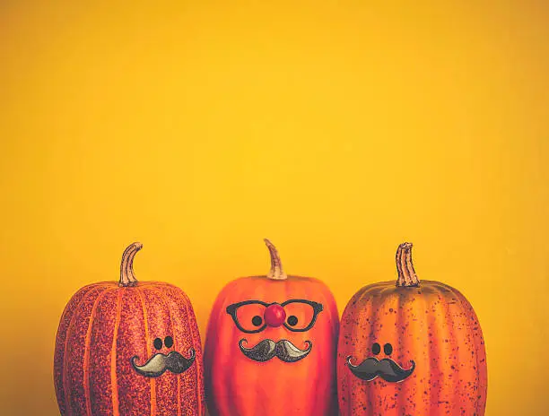 Photo of Three pumpkin characters wearing mustaches for Halloween