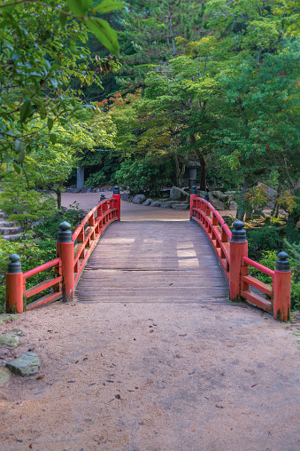 Miyajima, Japan - August 14, 2015: Traditional Japanese style bridge at the entrance to Momiji-dani Park on Miyajima island in Japan