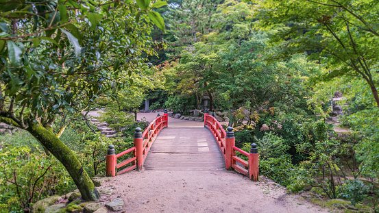 Miyajima, Japan - August 14, 2015: Traditional Japanese style bridge at the entrance to Momiji-dani Park on Miyajima island in Japan