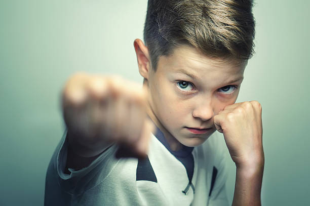 istock Angry child boy in white t-shirt training box punch. 598065270
