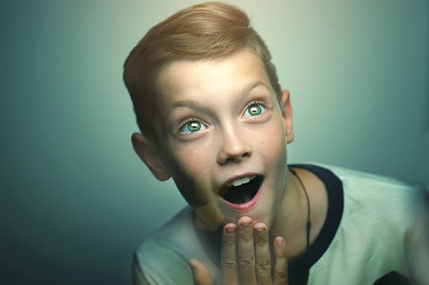 Surprised blond happy teenage boy with stylish haircut and bright eyes.